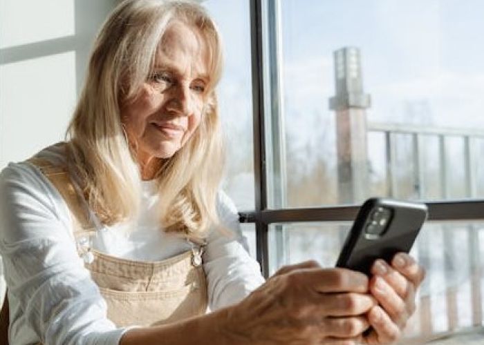 En kvinna läser sms på sin mobiltelefon
