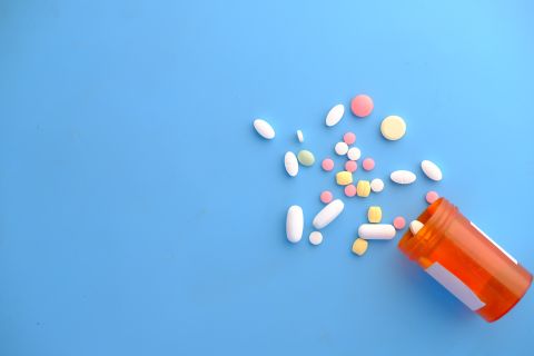 Tabletter som hälls ut från en plastburk