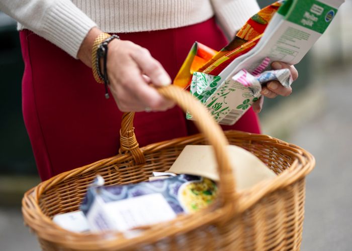 En person håller en kort med vikta hushållsförpackningar